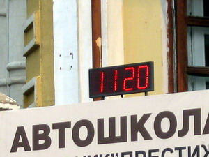 Маленькие часы на рекламном стенде в центре города
