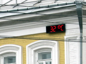 Уличные светодиодные часы на фасаде дома центре города