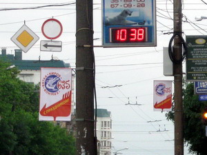 Уличные светодиодные часы на рекламной вывеске центре города
